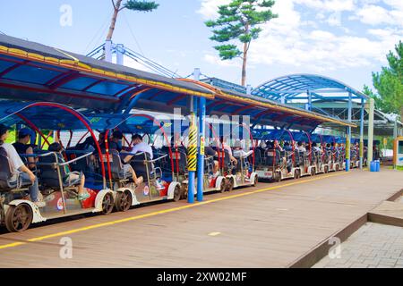 Samcheok, Corea del Sud - 29 luglio 2024: I turisti si preparano a partire sulla Samcheok Marine Rail Bike dalla stazione di Gungchon, come bici multipla a quattro posti Foto Stock