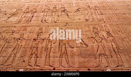 Bassorilievo murale raffigurante Tolomeo V Epifane che fanno offerte a Horus e Hathor nel tempio di Horus a Edfu costruito durante l'era tolemaica tra il 237 e il 57 a.C. vicino ad Assuan, in Egitto Foto Stock