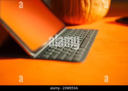 Modello dello schermo del notebook con zucca arancione. Schermata vuota della tavoletta grafica. Tastiera Foto Stock