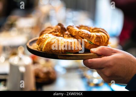 Colazione al ristorante. Croissant a mano Foto Stock