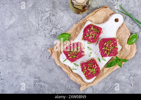 Tosta con barbabietola, noci tritate ed erbe aromatiche. Bruschetta vegana con barbabietola Foto Stock