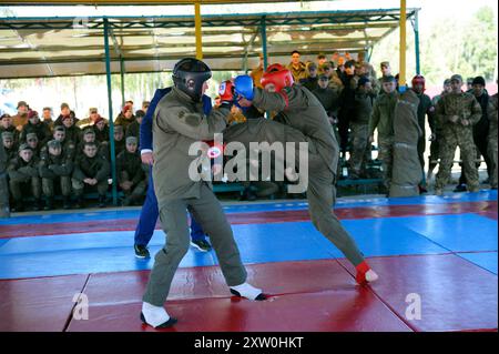 Combattente dell'esercito. Due combattenti che combattono su un ring, che guardano l'arbitro. Una lotta tra uomini, istruttore ufficiale e soldato tirocinante, dilettanti. Foto Stock