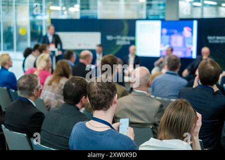 I professionisti aziendali si sono riuniti a una conferenza per un seminario. Pubblico coinvolto che partecipa a una presentazione. Foto Stock