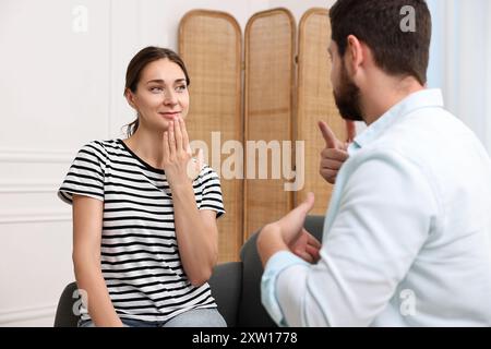 Uomo e donna che usano il linguaggio dei segni per comunicare a casa Foto Stock