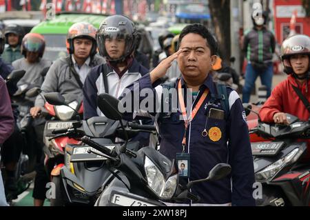 Bogor, Giava Occidentale, Indonesia. 17 agosto 2024. Una sosta per gli automobilisti per salutare la bandiera nazionale indonesiana su una strada per celebrare il 79° giorno dell'indipendenza indonesiana a Bogor, Giava Occidentale, Indonesia. (Credit Image: © Adriana Adie/ZUMA Press Wire) SOLO PER USO EDITORIALE! Non per USO commerciale! Foto Stock