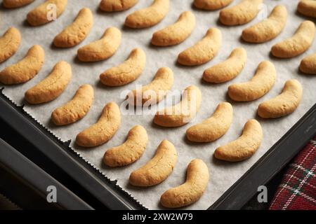 Pasticceria dolce al forno su carta pergamena - preparazione di mezzaluna di vaniglia fatte in casa o Kipferl, biscotti di Natale fatti in casa Foto Stock