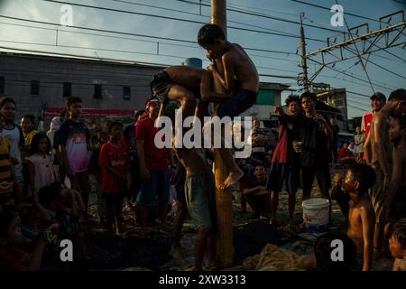 Giacarta, Giacarta, Indonesia. 17 agosto 2024. I bambini partecipano al gioco tradizionale chiamato ''Panjat Pinang'' per scalare pali d'albero ingrassati e raccogliere premi in cima durante una celebrazione del 79° giorno dell'indipendenza indonesiana a Giacarta. (Immagine di credito: © Asyraf Rasid/ZUMA Press Wire) SOLO PER USO EDITORIALE! Non per USO commerciale! Crediti: ZUMA Press, Inc./Alamy Live News Foto Stock