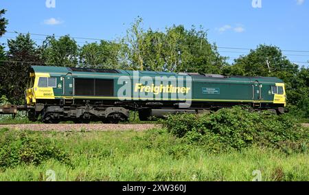 Freightliner classe 66 diesel sul retro del treno merci diretto a sud verso Ely, Cambridgeshire, Inghilterra, Regno Unito Foto Stock