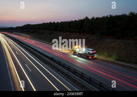il soccorso stradale trasporta un veicolo di lusso in difficoltà durante i lavori in autostrada Foto Stock