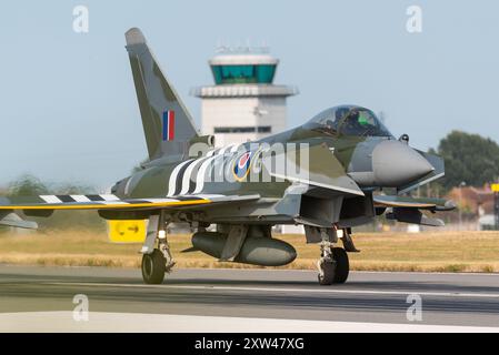 Aeroporto Southend di Londra, Essex, Regno Unito. 17 agosto 2024. La Royal Air Force ha inviato un caccia Eurofighter Typhoon all'aeroporto civile da cui operare per l'Eastbourne Airshow di quattro giorni. Uno dei getti è appositamente dipinto in uno schema di anniversario del D-Day della RAF in tempo di guerra con «strisce di invasione». Rullaggio dopo l'atterraggio dopo la visualizzazione Foto Stock