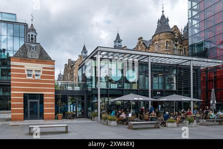 Edifici vecchi e moderni a Quartermile con persone sedute al Soderberg Cafe, Edimburgo, Scozia, Regno Unito Foto Stock