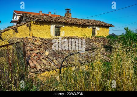 Una casa di fango, dipinta di giallo, ora in rovina e circondata da erbacce e brambles. Colle Marcone, Provincia di Chieti, Abruzzo, Italia, Europa Foto Stock