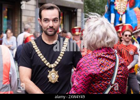 Belfast Mela Carnival Parade - Consigliere Micky Murray, Lord Mayor che conduce le feste attraverso la città. Belfast, Regno Unito - 17 agosto 2024. Foto Stock