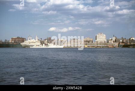 New York, Stati Uniti. 1959 settembre – la nave di linea Holland America Line, SS Rotterdam, ormeggiata sul fiume Hudson, New York, dopo il suo viaggio inaugurale. Tra i passeggeri vi era la principessa Beatrice dei Paesi Bassi. Ormeggiato accanto al Rotterdam vi è il cacciatorpediniere classe Holland della Royal Netherlands Navy, HNLMS Gelderland (D811). Sia la Principessa Beatrix che la Gheldria stavano visitando New York per le celebrazioni in occasione del 350° anniversario del viaggio di Henry Hudson. La fotografia mostra anche i lavori di costruzione del Pier 40, un nuovo terminal passeggeri e merci che serve la Holland America Line. Foto Stock