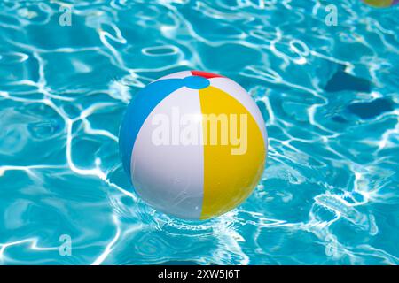 Beach ball. Colorato pallone gonfiabile che galleggia in piscina. Concetto di vacanza estiva. Pubblicità estiva Foto Stock