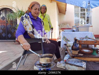 Windhoek, Namibia. 17 agosto 2024. Una donna etiope tosta i chicchi di caffè al Green Market di Windhoek, Namibia, il 17 agosto 2024. PER ANDARE CON "Feature: Il mercato verde stimola il commercio agricolo, il benessere sociale nella capitale della Namibia" credito: Ndalimpinga Iita/Xinhua/Alamy Live News Foto Stock