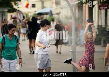 Varsavia, Polonia. 17 agosto 2024. Il 17 agosto 2024, i turisti godono di freschezza accanto a un sistema di raffreddamento a nebbia in mezzo all'ondata di caldo a Varsavia, Polonia. Crediti: Jaap Arriens/Xinhua/Alamy Live News Foto Stock