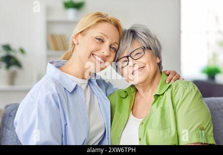 Sorridente, amorevole, anziana, matura madre e figlia adulta, si avvicinano alla giovane e premurosa donna Foto Stock