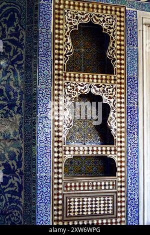 Primo piano dell'interno del Padiglione Baghdad del Palazzo Topkapi: Un armadio intarsiato con madreperla e un muro rivestito con piastrelle di ceramica Foto Stock