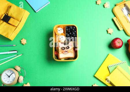 Composizione piatta con pranzo al sacco e spuntini sul tavolo verde Foto Stock