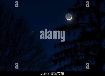 Earthshine e Giove al crepuscolo Foto Stock