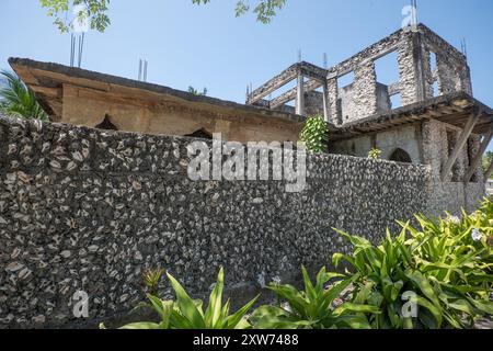 Muro di una casa fatta di conchiglie a Zanzibar - un esempio sorprendente di uso insostenibile delle risorse marine nelle pratiche di costruzione locali. Foto Stock