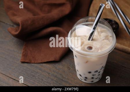 Saporito tè con bolle di latte in una tazza di plastica su un tavolo di legno, primo piano Foto Stock