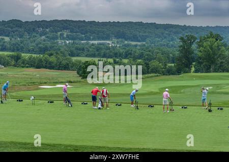 Uomini che colpiscono palle da golf nel campo pratica del country club, Pennsylvania, Stati Uniti Foto Stock
