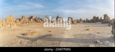 Paesaggio lunare di camini di pietra calcarea formazioni rocciose geologiche in un tramonto raggi sul fondo del lago salato essiccato Abbe, Gibuti Foto Stock