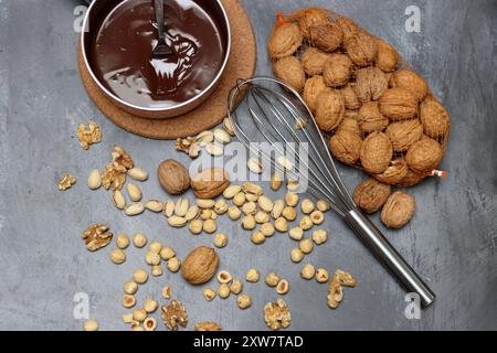 Cioccolato fatto in casa. Ganache al cioccolato con nocciole e noci su sfondo grigio con spazio per il testo. Foto Stock