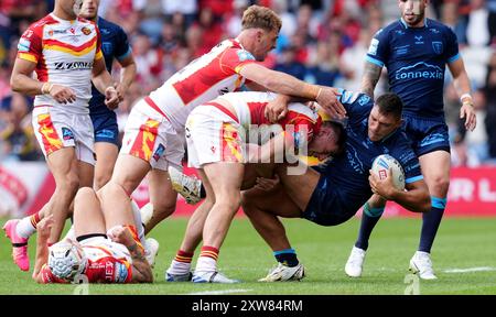 Ryan Hall di Hull KR (seconda a destra) è placcato da Tom Davies dei Catalans Dragons (centro) e Paul Seguier (sinistra) durante il Betfred Super League match a Elland Road, Leeds. Data foto: Domenica 18 agosto 2024. Foto Stock