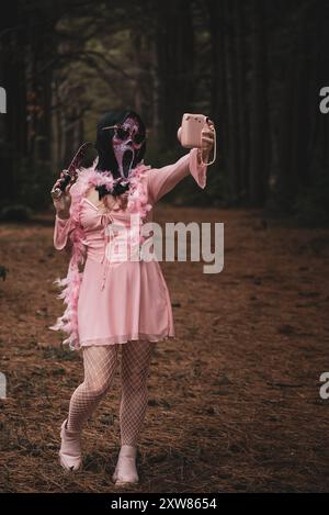donna che posa in costume rosa urla di halloween con foresta dorsale sullo sfondo Foto Stock