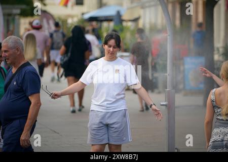 Varsavia, Polonia. 17 agosto 2024. Una donna cammina attraverso una stazione nebulizzata durante un'ondata di caldo a Varsavia, in Polonia, il 17 agosto 2024. L'ufficio meteorologico nazionale ha emesso un avviso per i prossimi giorni di un'onda di calore con temperature non inferiori a 28 gradi Celsius. (Foto di Jaap Arriens/Sipa USA) credito: SIPA USA/Alamy Live News Foto Stock