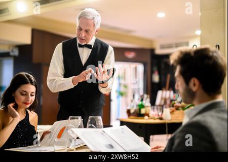 Cameriere prendendo gli ordini in un ristorante Foto Stock