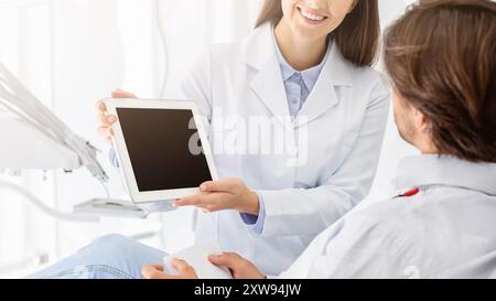 Chiusura del fustellato tavoletta digitale schermo azienda dal dentista Foto Stock