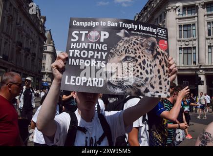 Londra, Regno Unito. 17 agosto 2024. Un manifestante tiene un cartello contro la caccia ai trofei durante la National Animal Rights March. La protesta annuale evidenzia la sofferenza e la morte di miliardi di animali in tutti i settori dell'attività umana, lotta per la liberazione degli animali e per la fine dello sfruttamento animale, e promuove il veganismo e uno stile di vita senza crudeltà. Credito: SOPA Images Limited/Alamy Live News Foto Stock