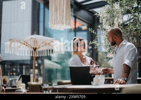 Colleghi d'affari che discutono di lavoro in un bar all'aperto in città Foto Stock