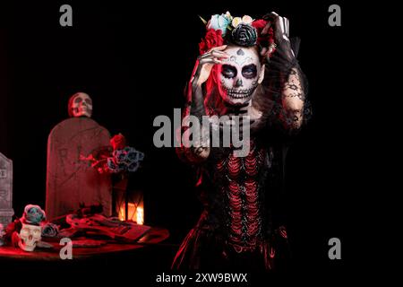 Ritratto di una ragazza inquietante al dia de los Muertes riti indigeni di onorare i morti. Donna che indossa un abito e una corona di fiori che partecipa all'evento Day of the Dead in onore del defunto Foto Stock