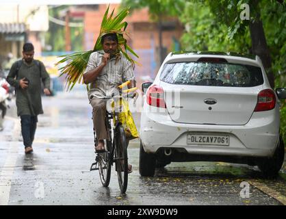 Nuova Delhi, India. 18 agosto 2024. NOIDA, INDIA - 18 AGOSTO: I pendolari escono durante la pioggia pomeridiana al settore 34, il 18 agosto 2024 a Noida, India. (Foto di Sunil Ghosh/Hindustan Times/Sipa USA ) credito: SIPA USA/Alamy Live News Foto Stock