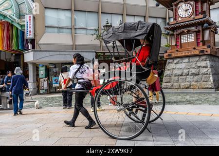 Un tradizionale risciò, un carro a due ruote trainato compra una donna, a Dogo Yunomachi, nel centro di Matsuyama, nella regione di Shikoku, in Giappone Foto Stock