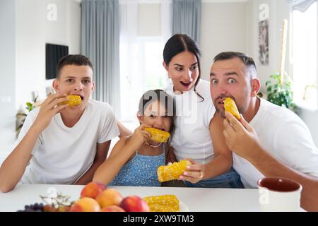 In famiglia, durante un pomeriggio di sole, potrai gustare il mais fresco sulla pancetta in una cucina luminosa Foto Stock