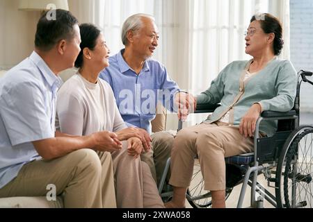 gruppo di felici riunioni asiatiche senior a casa con una bella chiacchierata Foto Stock