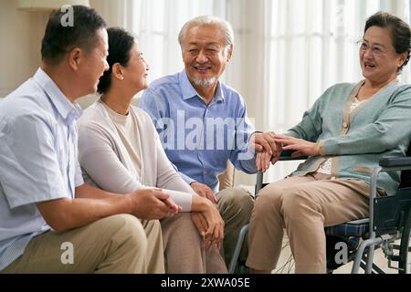 gruppo di felici riunioni asiatiche senior a casa con una bella chiacchierata Foto Stock