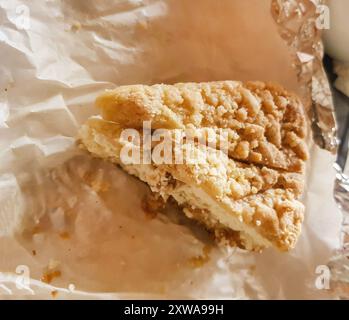 Due pezzi di deliziosa torta di pasta frolla fatta in casa su carta da forno in pergamena Foto Stock