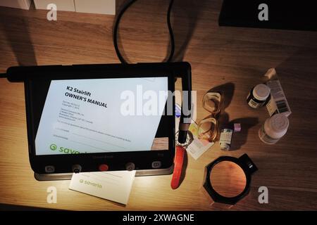 Vivere con l'handicap della visione bassa è aiutato con ausili per la visione come lenti di ingrandimento video e schermi per computer per facilitare la lettura di piccole stampe Foto Stock