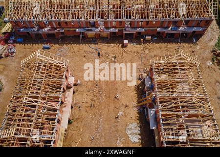 Nuova casa in costruzione, sistema di capriate in legno che forma il tetto. Processo di costruzione del progetto. Foto Stock