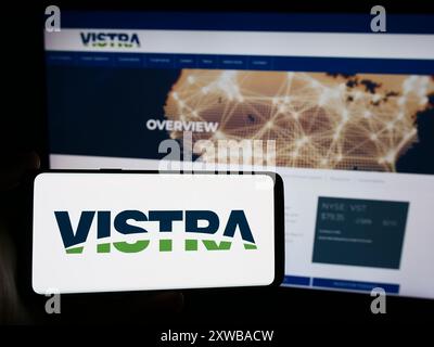 Persona che possiede uno smartphone con il logo della società energetica statunitense Vistra Corp. Davanti al sito web. Mettere a fuoco il display del telefono. Foto Stock