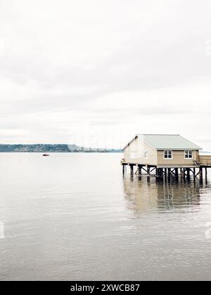 Barca da pesca rossa nell'acqua di Puget Sound lungo l'orizzonte lontano Foto Stock