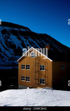 Edificio giallo nella innevata Longyearbyen, Svalbard Foto Stock