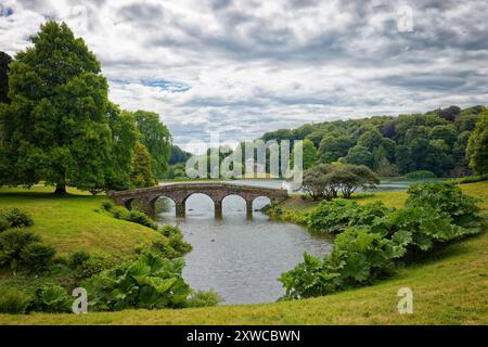 Il ponte Palladiano sul lago con il Pantheon in lontananza a Stourhead a Warminster nel Wiltshire Inghilterra Regno Unito Foto Stock